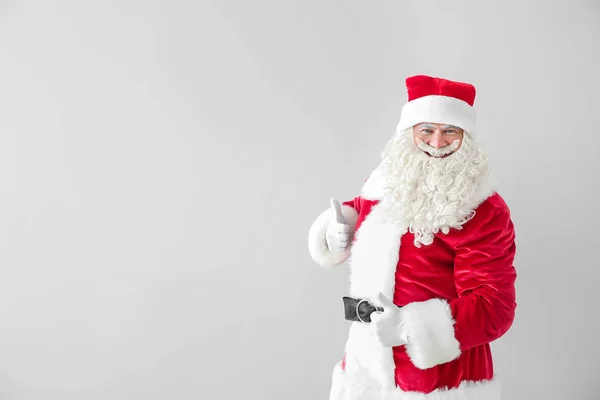 Retrato de Santa Claus mostrando el pulgar hacia arriba sobre fondo claro —  Fotos de Stock