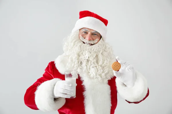 Ritratto di Babbo Natale con latte e biscotti su sfondo chiaro — Foto Stock