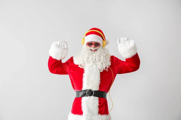 Retrato de Santa Claus escuchando música sobre fondo claro —  Fotos de Stock