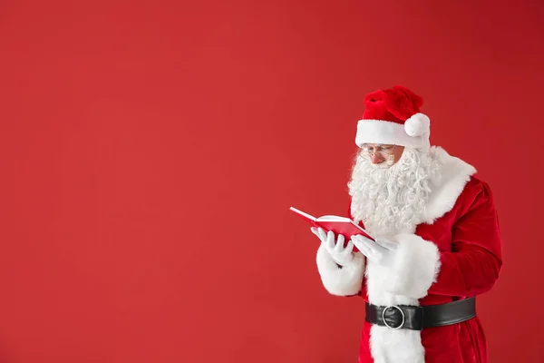 Portrait of Santa Claus with book on color background — Stock Photo, Image
