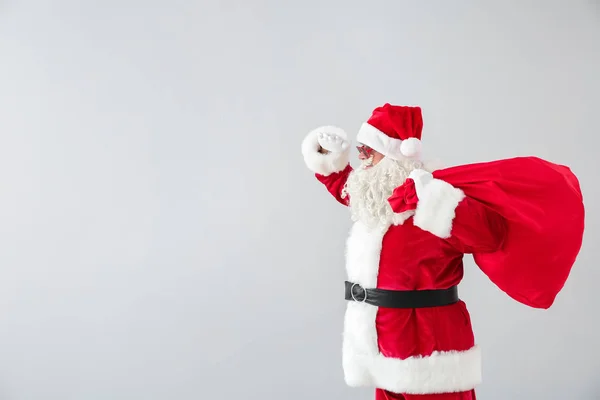 Portret van de kerstman met zak op lichte achtergrond — Stockfoto