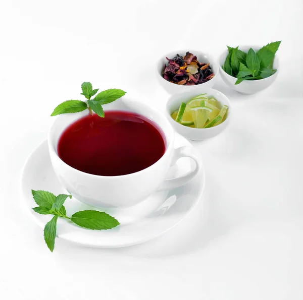 Cup of hot tea with lime and mint on white background — Stock Photo, Image