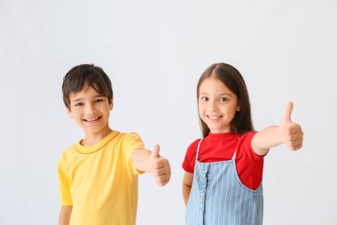 Hafif arka planda başparmak-up hareketi gösteren mutlu çocukların portresi
