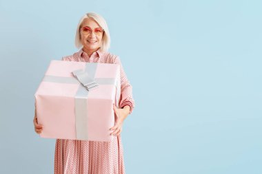 Renkli arka planda hediye kutusu ile Olgun kadın