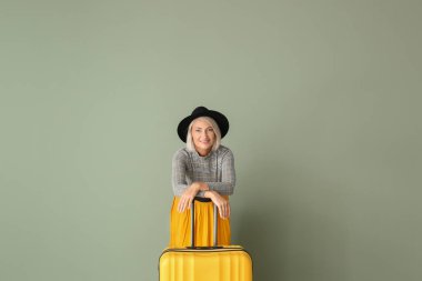 Renkli arka planda bavul ile Olgun kadın