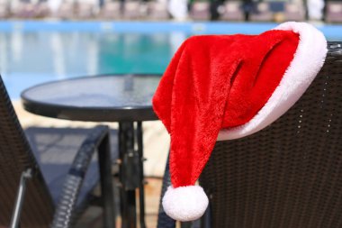 Tatil beldesinde şezlong üzerinde Santa şapka