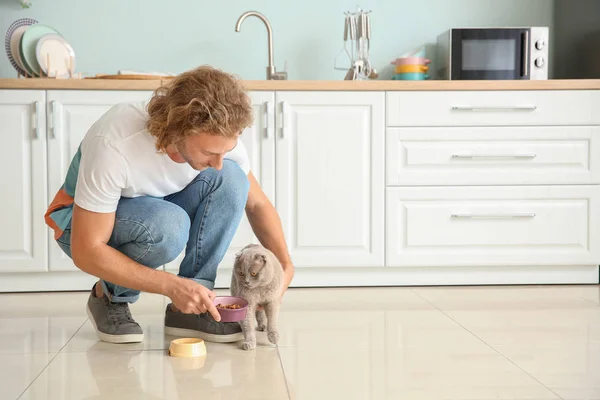 Hombre alimentación lindo divertido gato en cocina — Foto de Stock