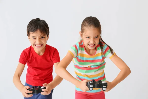 Emotionale Kinder, die Videospiele auf hellem Hintergrund spielen — Stockfoto