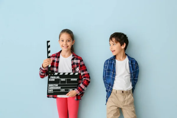 Cute little children with movie clapper on color background — Stock Photo, Image