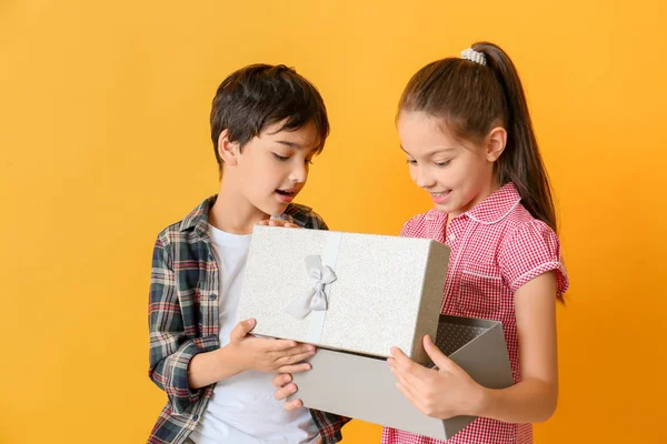 Sevimli küçük çocuklar renkli arka plan üzerinde hediye kutusu açılış