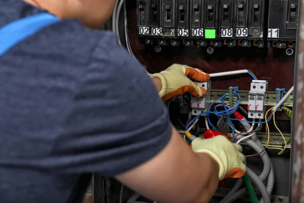 Eletricista conectando fios no armário elétrico — Fotografia de Stock