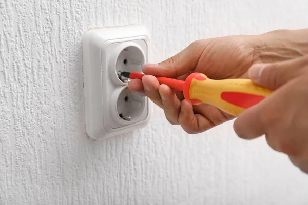 Electrician repairing socket in room, closeup