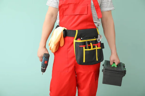 Male electrician with tools on color background — Stock Photo, Image