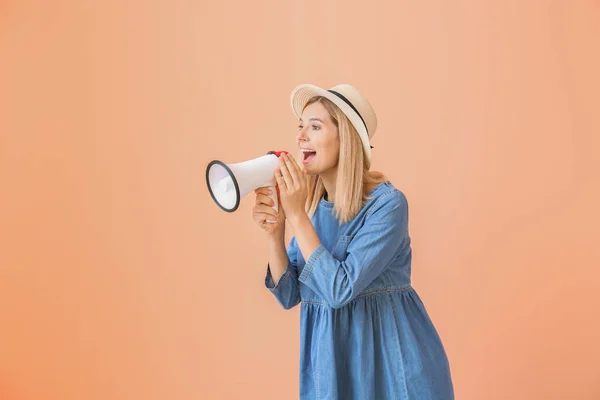 Screaming woman with megaphone on color background — Stock Photo, Image