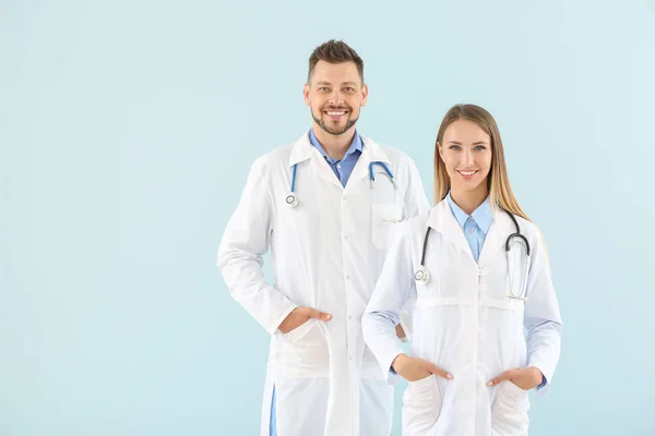 Male and female doctors on light color background — Stock Photo, Image