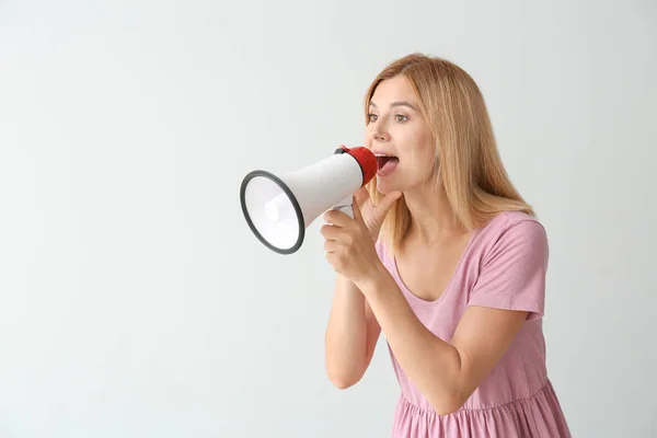 Screaming woman with megaphone on light background — Stock Photo, Image