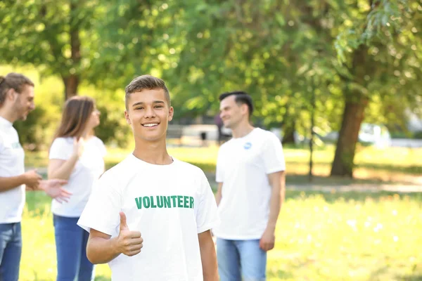 Portrait of teenage volunteer showing thumb-up outdoors — Stock Photo, Image