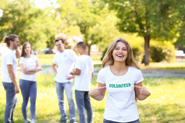 Female volunteer pointing at her t-shirt outdoors