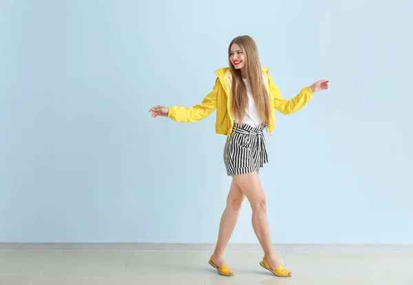 Happy young woman near color wall