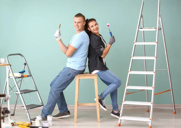 Feliz joven pareja haciendo reparación en su nueva casa — Foto de Stock