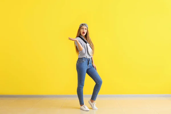 Шокована молода жінка біля кольорової стіни — стокове фото