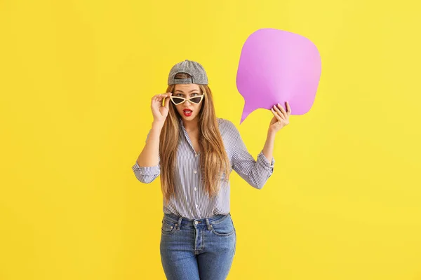 Surprised young woman with speech bubble on color background — Stock Photo, Image