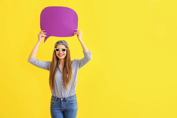 Happy young woman with speech bubble on color background — Stock Photo, Image