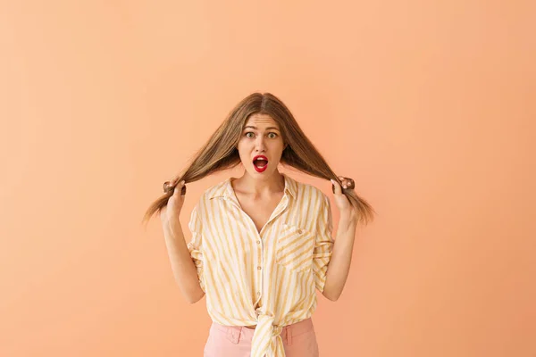 Surprised young woman on color background — Stock Photo, Image