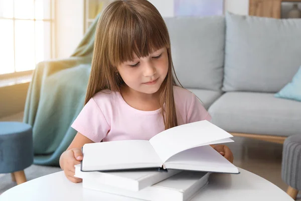 Cute little girl reading book at home — Stock Photo, Image