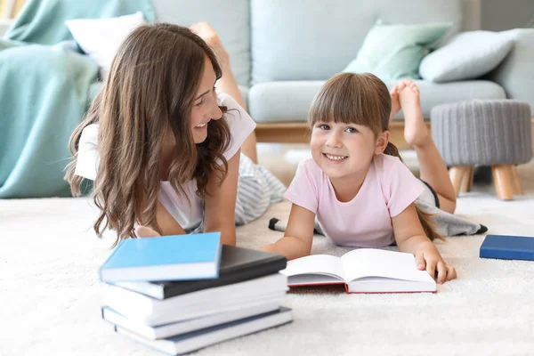 Sevimli küçük kız ve ablası evde kitap okuma — Stok fotoğraf