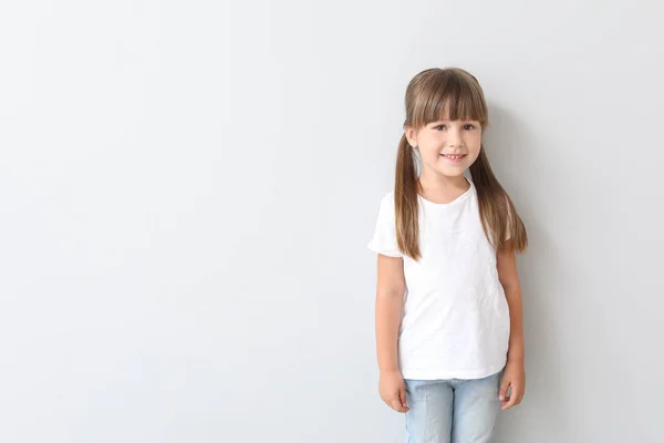 Little girl in stylish t-shirt on light background — Stock Photo, Image