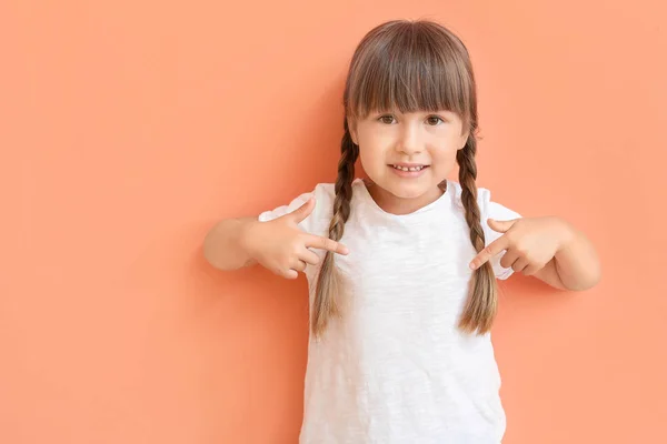 Menina apontando para sua camiseta no fundo de cor — Fotografia de Stock