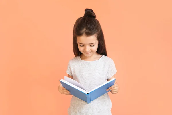 Χαριτωμένο κοριτσάκι με το βιβλίο στο φόντο χρώμα — Φωτογραφία Αρχείου