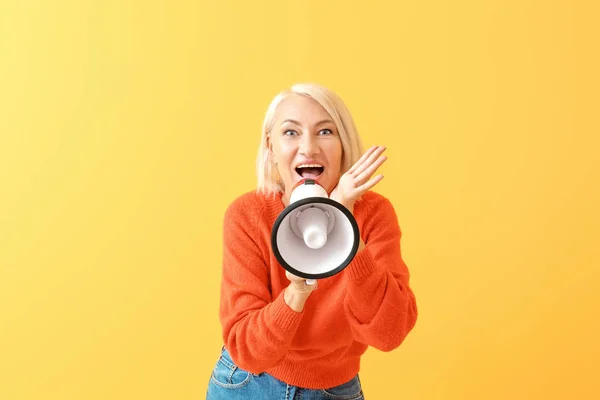 Mujer madura con megáfono sobre fondo de color — Foto de Stock