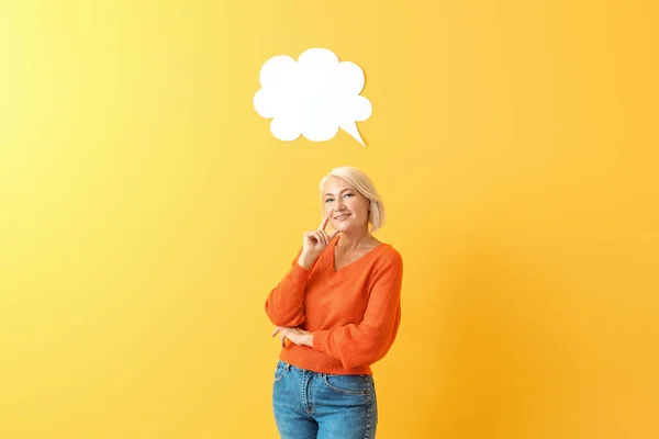 Stylish mature woman with blank speech bubble on color background — Stock Photo, Image