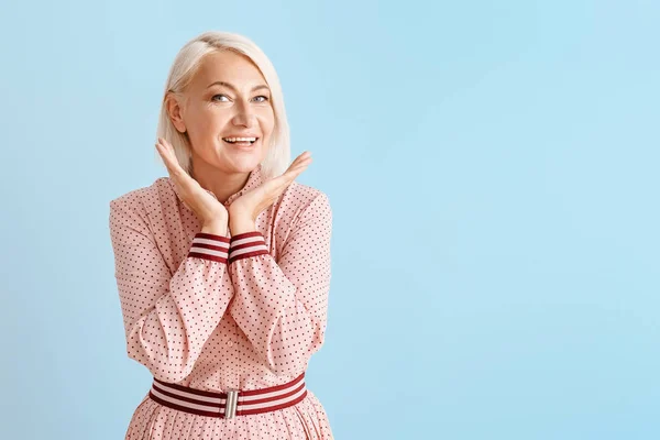 Stijlvolle rijpe vrouw op kleur achtergrond — Stockfoto