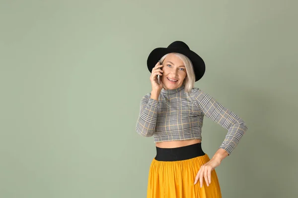 Mulher madura elegante falando por telefone no fundo de cor — Fotografia de Stock