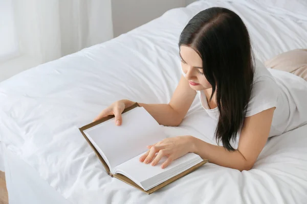 Bela jovem mulher ler livro no quarto — Fotografia de Stock