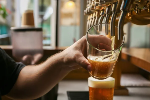 Barman pouring fresh beer in glass, closeup — Stock Photo, Image