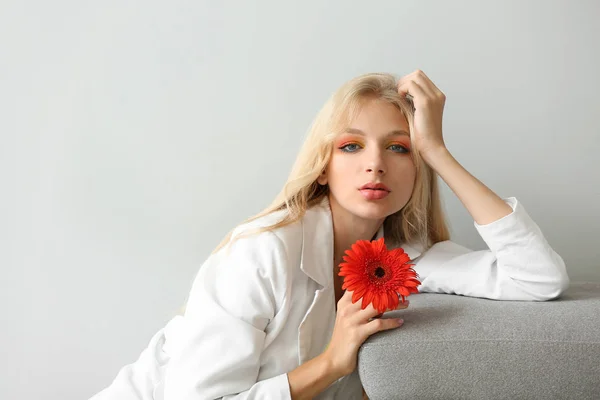 Beautiful young woman with gerbera flower on white background — Stock Photo, Image