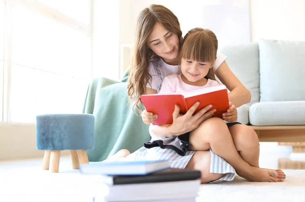 Cute little girl and her elder sister reading book at home — Stock Image Cute little girl and her elder sister reading book at home Royalty Free Stock Photos
