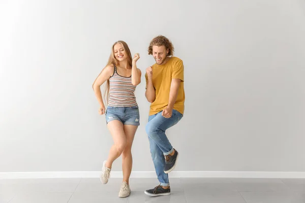 Cool pareja joven bailando contra la pared blanca — Foto de Stock