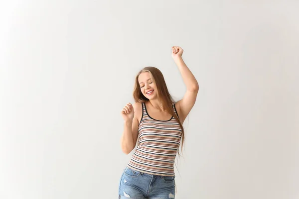 Cool young woman dancing against white background — Stock Photo, Image