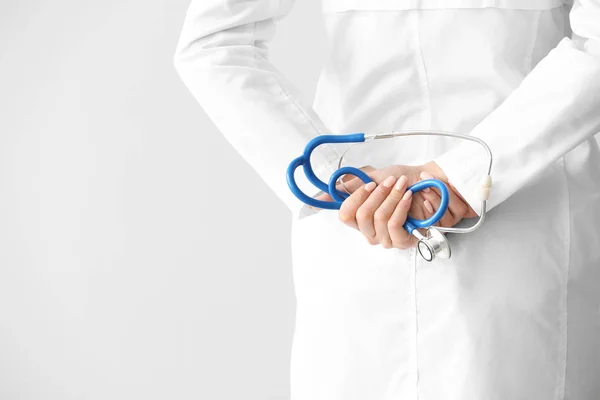 Żeński lekarz z stetoskop na jasnym tle, zbliżenie — Zdjęcie stockowe