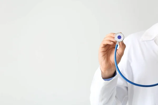 Medico maschile con stetoscopio su sfondo chiaro, primo piano — Foto Stock