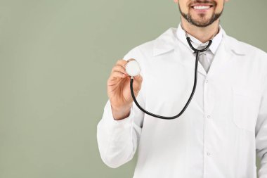 Renk arka plan üzerinde stetoskop ile erkek doktor