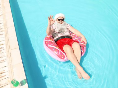 Noel Baba yüzme havuzunda şişme halka üzerinde rahatlatıcı
