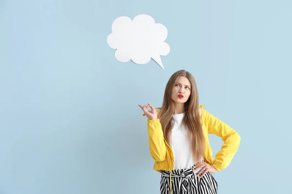 Thoughtful young woman with speech bubble on color background — Stock Photo, Image