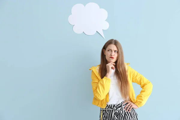 Thoughtful young woman with speech bubble on color background — Stock Photo, Image