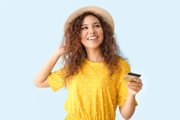 Gelukkig Afro-Amerikaanse vrouw met creditcard op lichte kleur achtergrond — Stockfoto